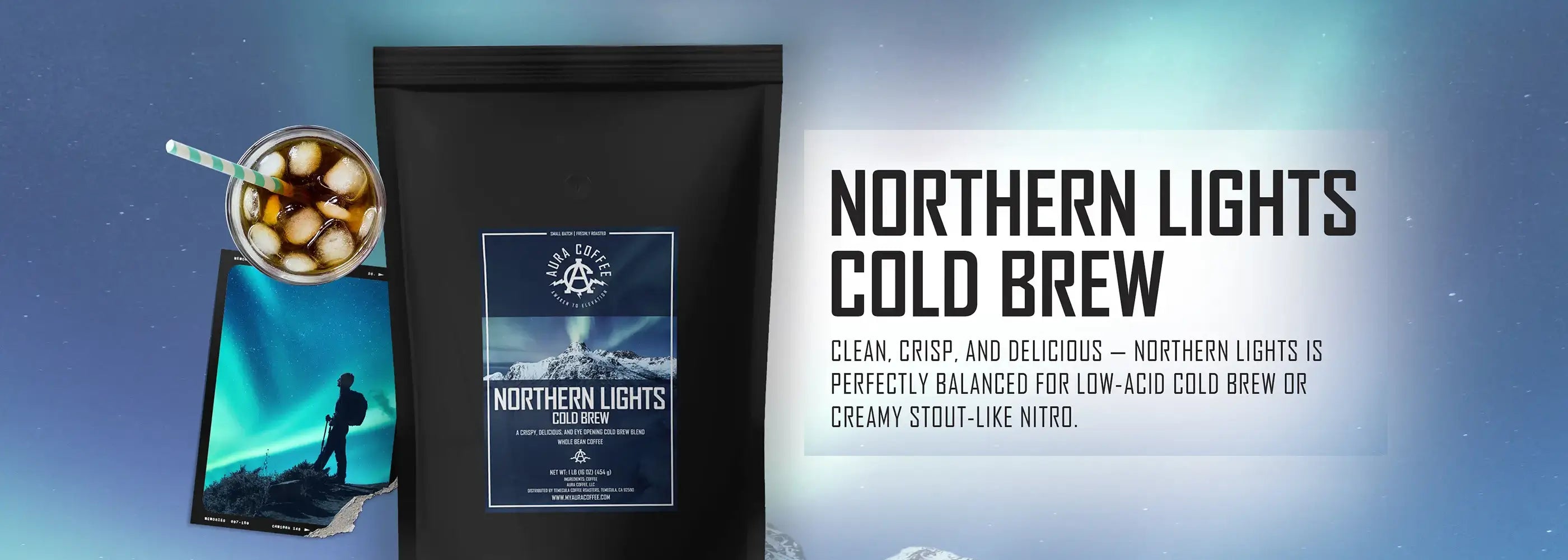 A black bag of "Northern Lights Cold Brew" coffee with a label featuring a mountain landscape under the Northern Lights, next to a glass of iced coffee and a postcard with a similar aurora borealis theme.