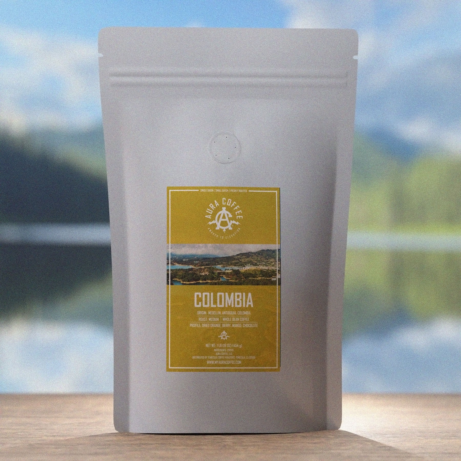 Aura Coffee Colombia Single Origin Coffee Pouch sitting on wooden table iconic Brazilian mountains and water in the background 