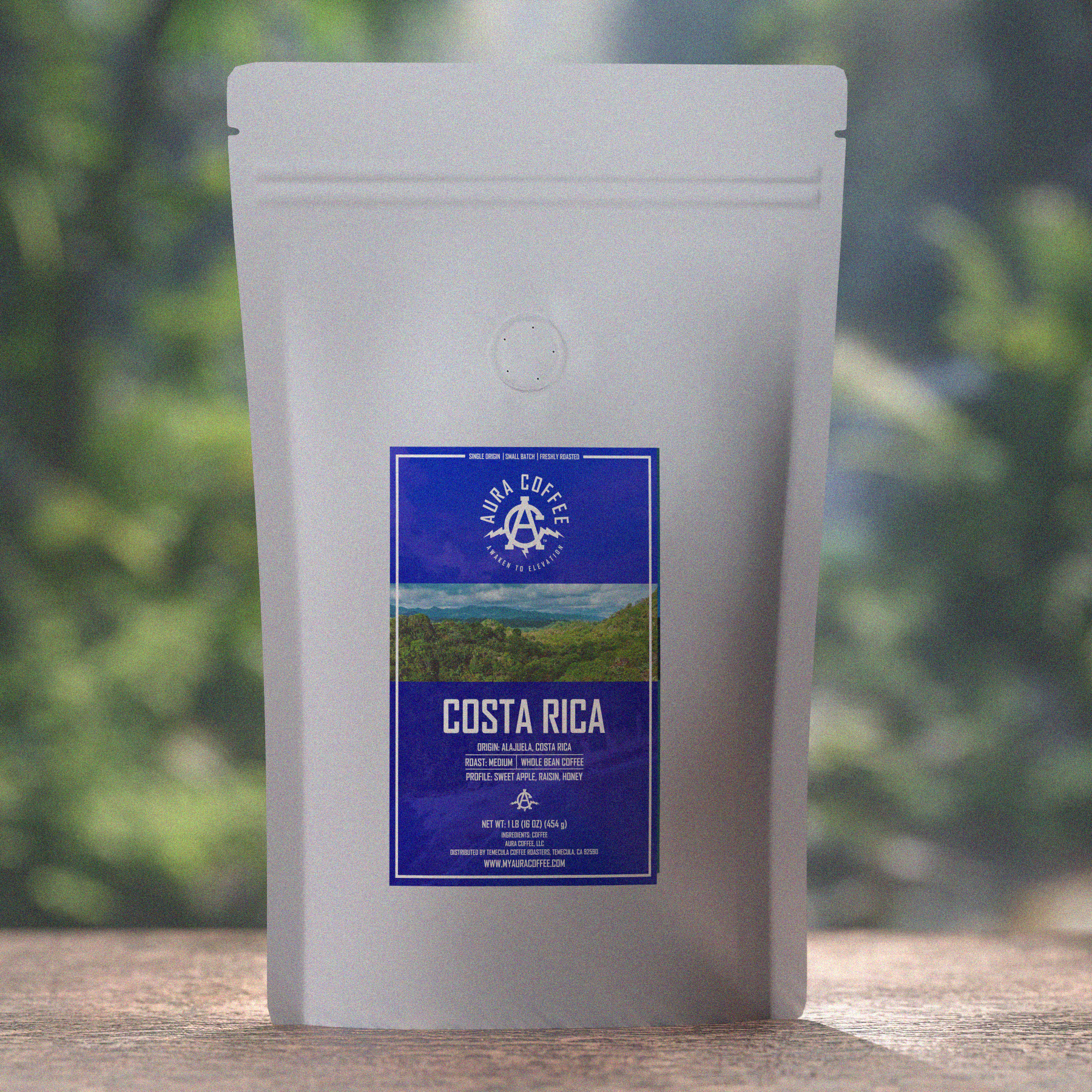 Aura Coffee Costa Rica Single Origin Coffee Pouch sitting on wooden table, green trees and water mist in the background