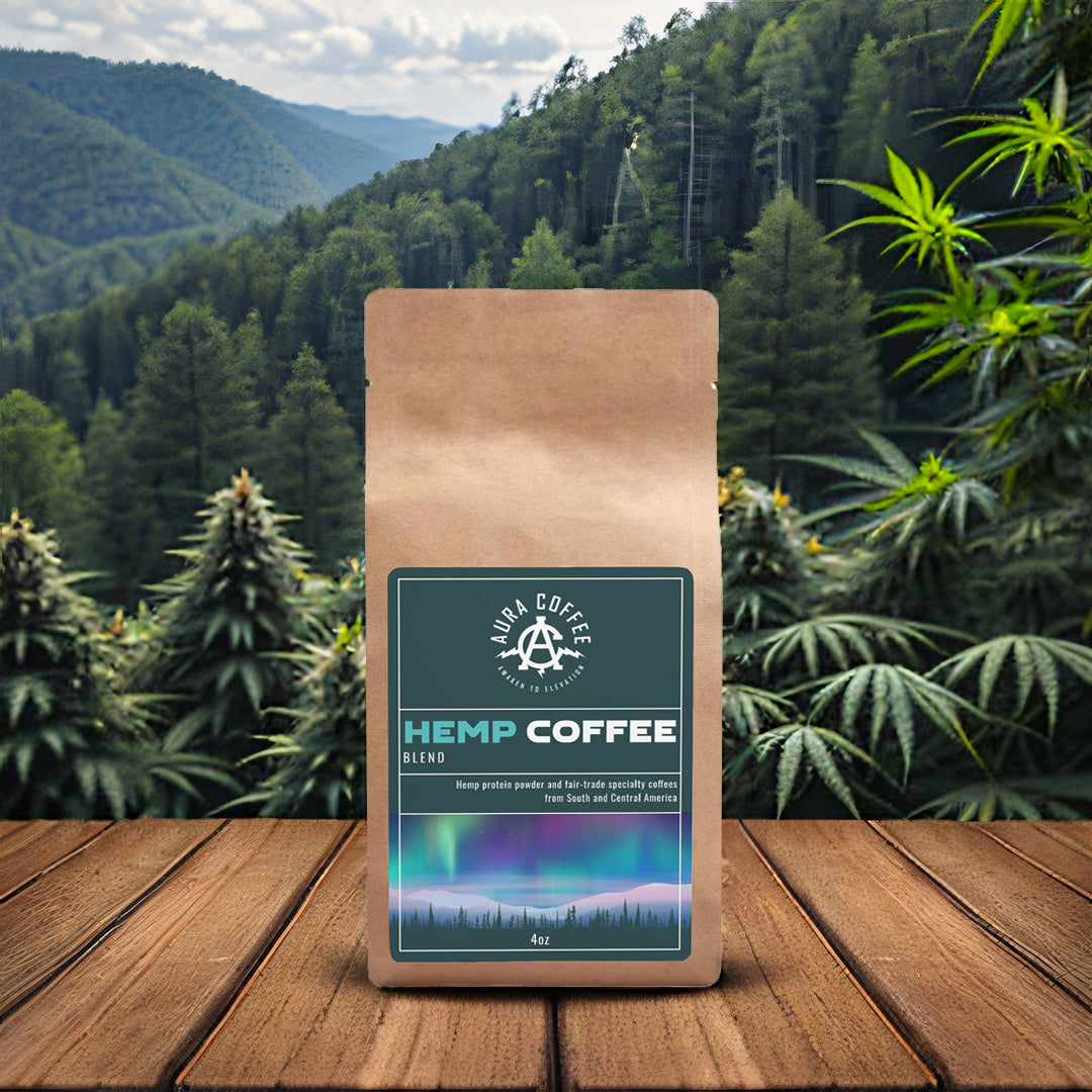 Package of Aura Coffee Hemp Coffee on a table with wild hemp growing in the background mountains