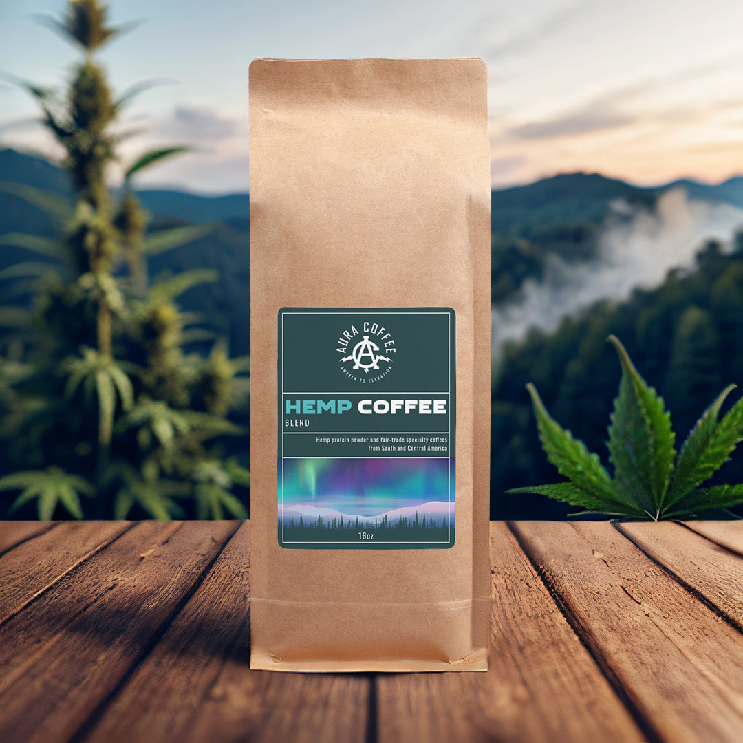 Package of Aura Coffee Hemp Coffee on a table with wild hemp growing in the background mountains