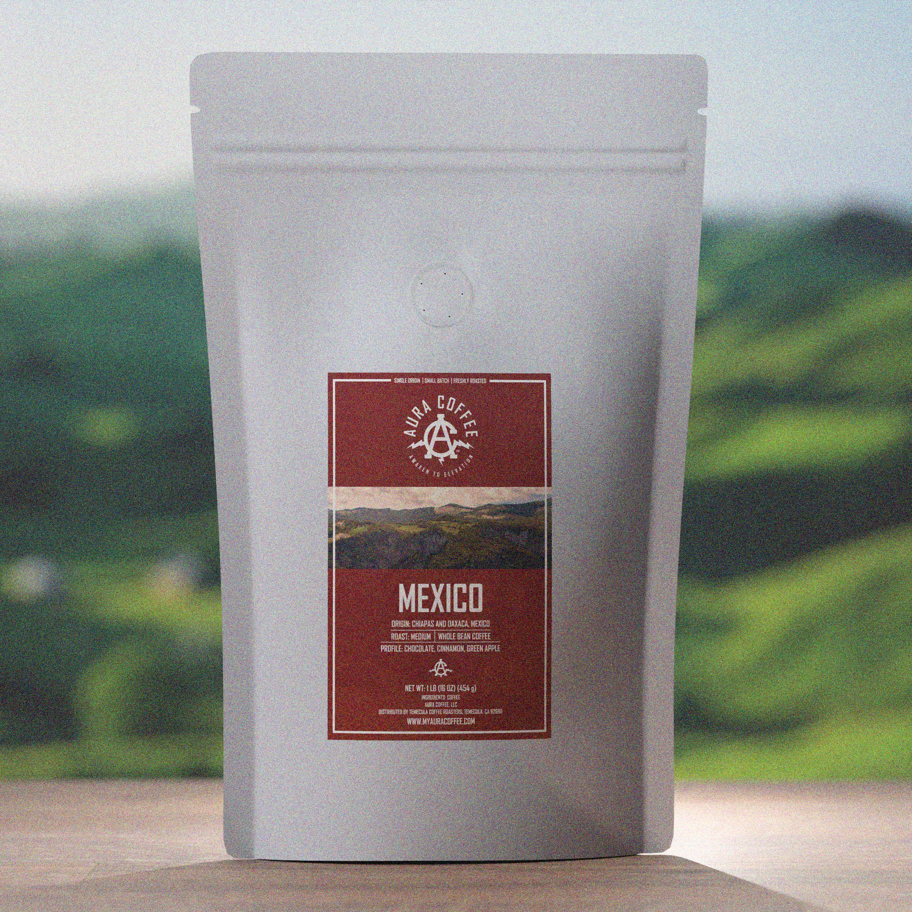 Bag of Aura Coffee Single Origin Mexico Coffee on a table with green rolling hills in the background