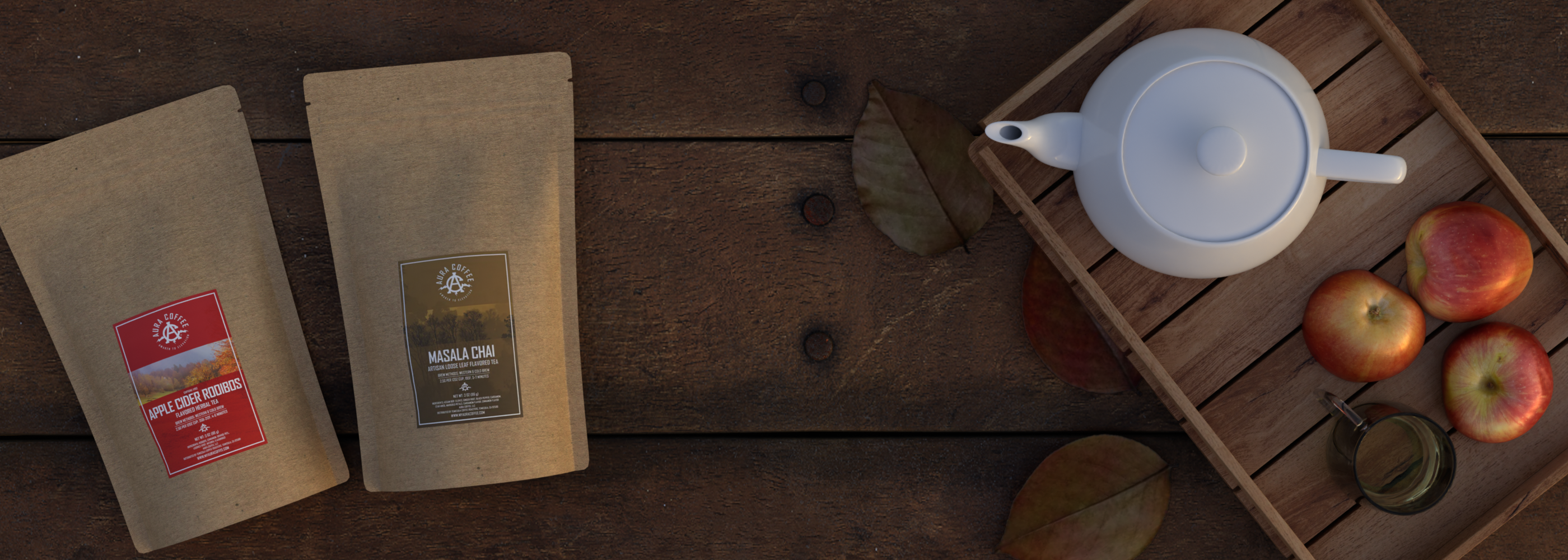 Aura Apple Cider Rooibos, Aura Masala Chai Tea Blends on table next to fall leaves, apples, and a tea kettle.